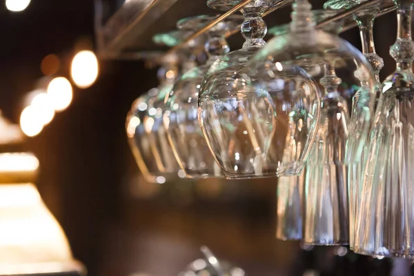 Glasses hanging on bar rack close up — Stock Photo, Image