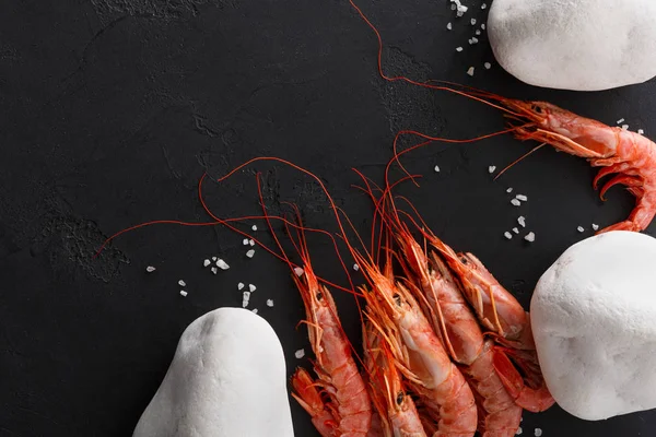 Siyah arka plan üzerine beyaz taşlarla karides