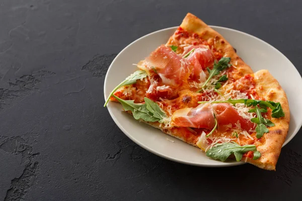 Dilimlenmiş pizza jambon ve roket salata ile