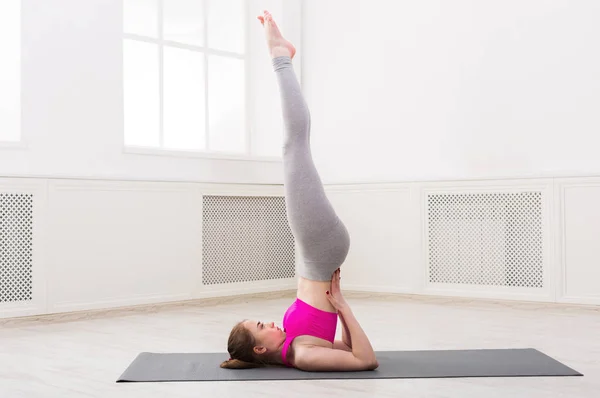 Frau trainiert Yoga in Schultersteherpose. — Stockfoto