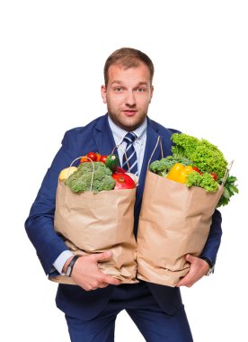 Genç işadamı alışveriş çantası beyaz arka plan üzerinde izole sebze dolu holding.