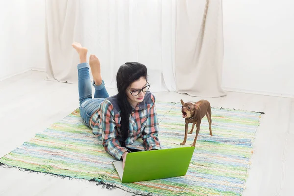 Dizüstü bilgisayar ve köpek katta genç kız