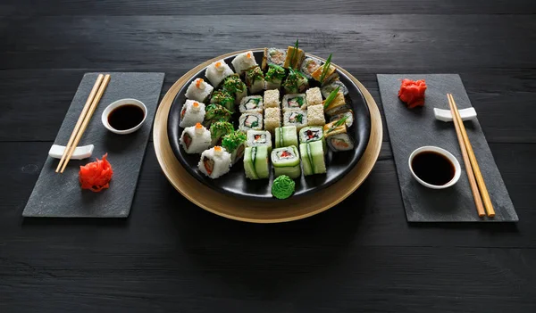 Set de sushi maki y rollos en madera rústica negra —  Fotos de Stock