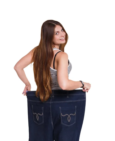 Žena nosí džíny mnohem větší velikost izolované na bílém pozadí. — Stock fotografie