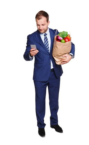 Alışveriş çantası beyaz arka plan üzerinde izole sebze dolu tutarak gülümseyen iş adamı. — Stok fotoğraf
