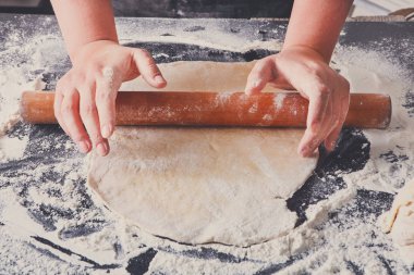 Fırın kavramı. El hamur siyah arka plan üzerine rulo..