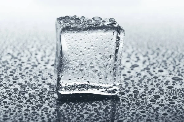 Transparante ice cube op glas met water druppels — Stockfoto