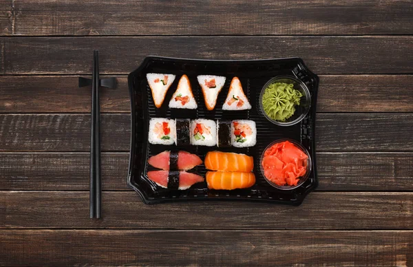 Entrega de comida japonesa. Conjunto de sushi e rolos vista superior em madeira — Fotografia de Stock