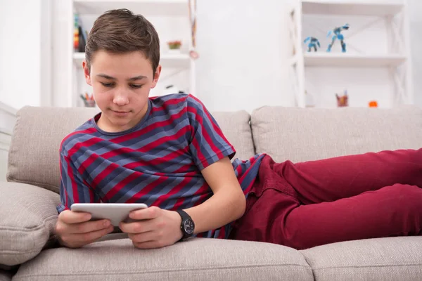 Tiener berichten online op smartphone in huiskamer — Stockfoto