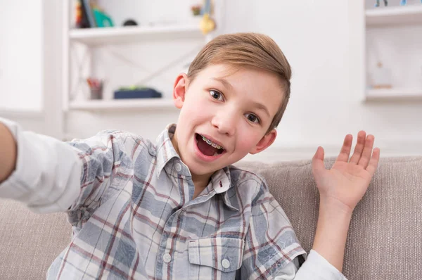 Erkek çocuk evde telefonla selfie alarak