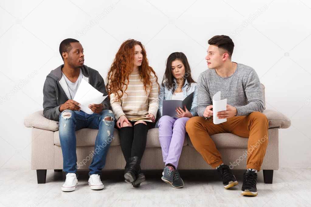 Diverse young students preparing for exam at home