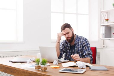 Modern beyaz ofis içinde laptop ile erkek programcı vurguladı yorgun