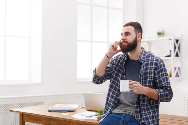 Yakışıklı erkek bu kahve içme ve cep telefonu Office konuşurken Yöneticisi