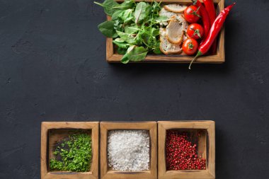 Malzemeler ve koyu arka plan üzerinde ahşap kutu otlar pişirme