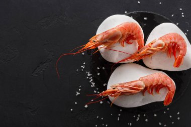 Siyah arka plan üzerine beyaz taşlarla karides