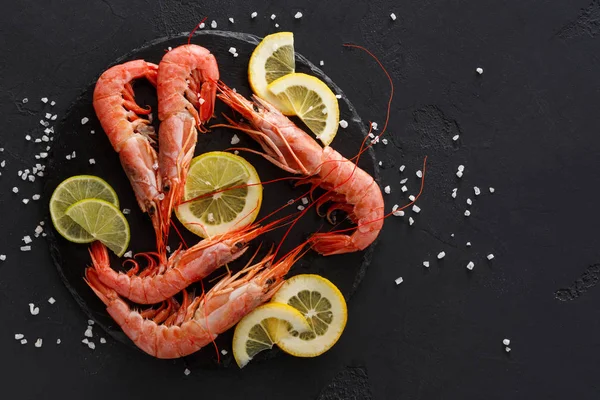 Siyah arka plan üzerine limon ve tuz ile karides