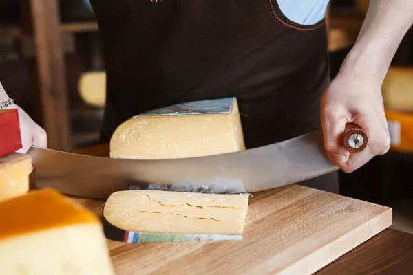 Резка твердых сыров в продуктовом магазине — стоковое фото