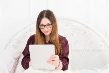 Tablet pc yatakta, kopya alanı kadın okur