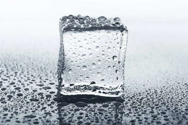 Cubo de gelo transparente em vidro com gotas de água — Fotografia de Stock
