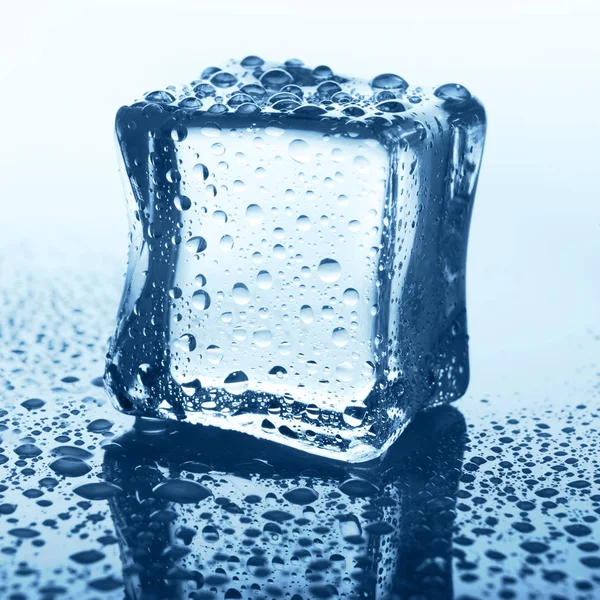 물으로 블루 유리에 투명 한 얼음 큐브 드롭 — 스톡 사진
