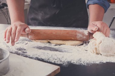 Fırın kavramı. El hamur siyah arka plan üzerine rulo..