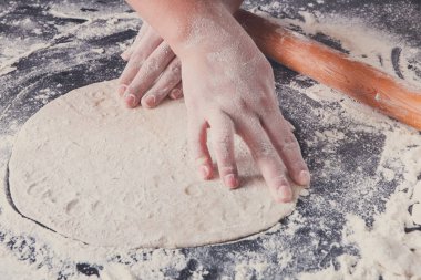 Fırın kavramı. El hamur siyah arka plan üzerine rulo..