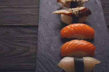 Suşi pov siyah ahşap arka plan üzerine kümesi