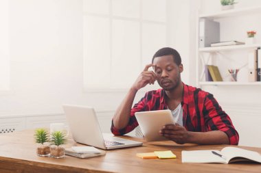 Ciddi genç siyah ofis, mutlu işadamı laptop ile çalışmak