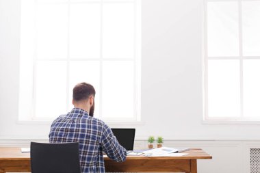 Genç işadamı modern beyaz ofis içinde laptop ile rahat