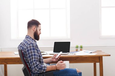 Genç işadamı modern beyaz ofis içinde laptop ile rahat