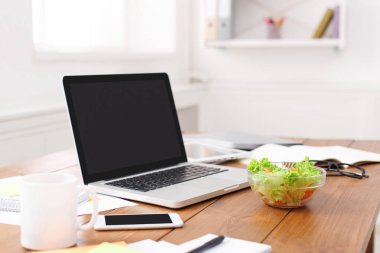 Ofis Masası salata, dizüstü bilgisayar, akıllı telefon ve diğer öğeleri ile yan görünüm