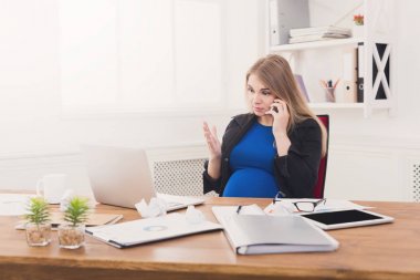 Hamile iş kadını telefonda konuşurken iş başında