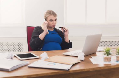 Hamile iş kadını telefonda konuşurken iş başında