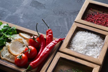 Malzemeler ve koyu arka plan üzerinde ahşap kutu otlar pişirme