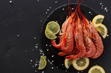 Siyah arka plan üzerine limon ve tuz ile karides