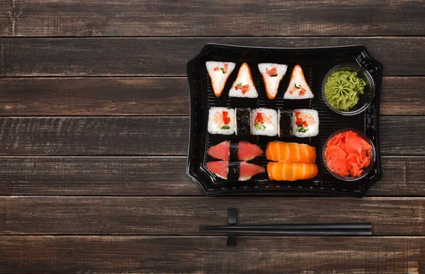 Japon yemekleri teslim. Suşi ve rulo üst görünümden odun kümesi