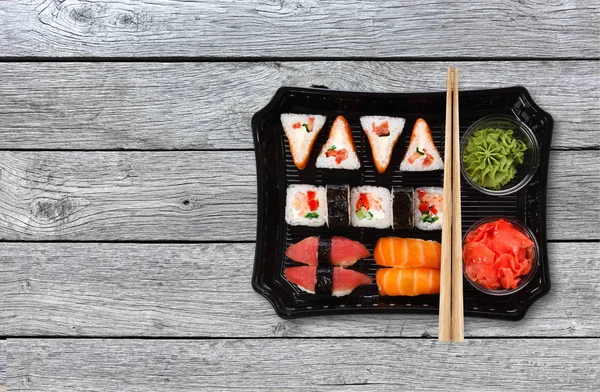 Japon yemekleri teslim. Suşi ve rulo üst görünümden odun kümesi