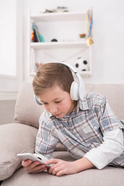 Tiener berichten online op smartphone in huiskamer — Stockfoto