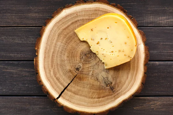 Pedazo de queso de gouda en disco de madera natural —  Fotos de Stock