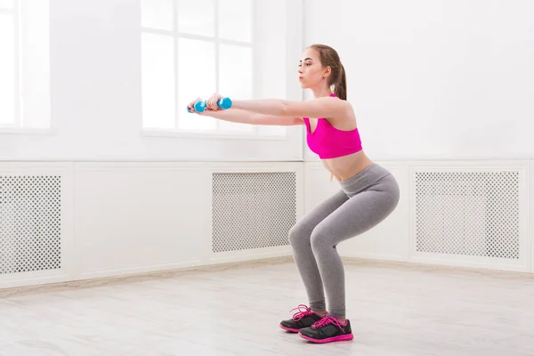 Fitness woman doing squat on white background — Stock Photo, Image