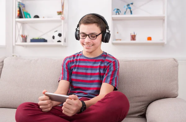 Genç çocuk oyun mobil oyun evde gülümseyen