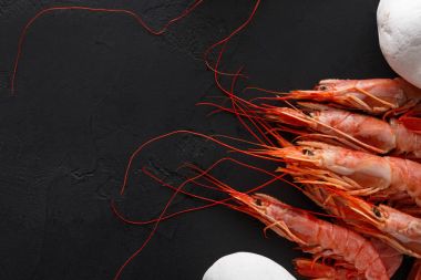 Siyah arka plan üzerine beyaz taşlarla karides