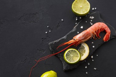 Siyah arka plan üzerine limon ve tuz ile karides