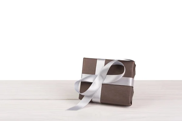 Christmas holiday gift box wrapped in paper on white wood — Stock Photo, Image