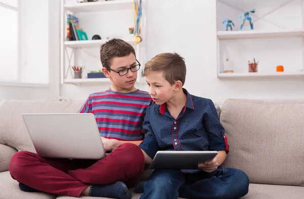 Zwei Teenager mit Gadgets auf der Couch zu Hause — Stockfoto