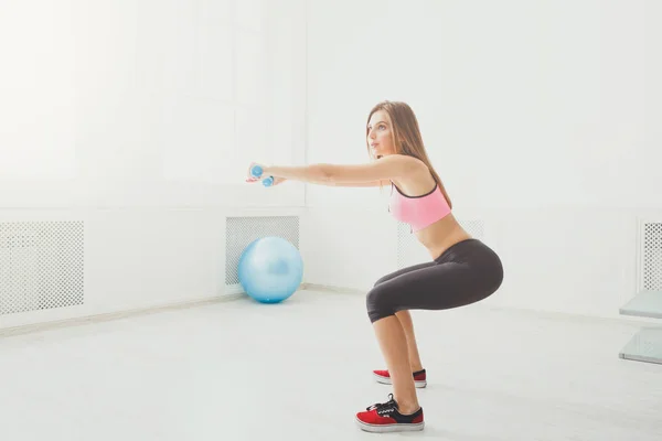 Joven hermosa mujer en ropa deportiva haciendo sentadilla — Foto de Stock