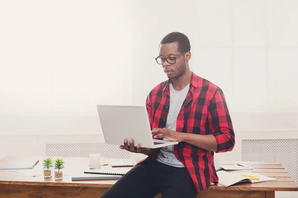 Pensive чорний бізнесмен в кабінеті, робота з ноутбуком — стокове фото