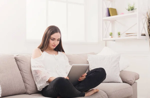 Jonge vrouw thuis met tablet — Stockfoto