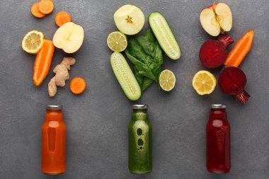 Smoothies gri arka plan üzerinde cam şişelerde malzemelerle Detoks.