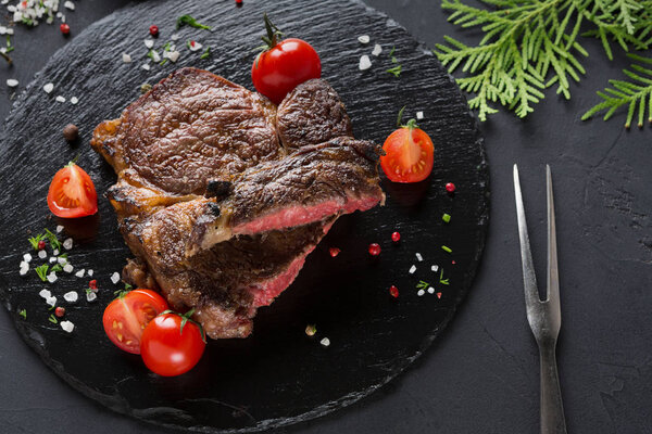 Rare rib eye steak on dark plate, closeup